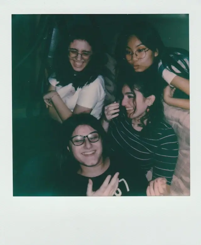 Friends talking and laughing around a restaurant table in the evening